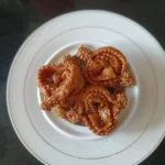 A close-up of traditional Moroccan Halwa Chebakia, deep-fried sesame cookies coated in honey and sprinkled with sesame seeds.